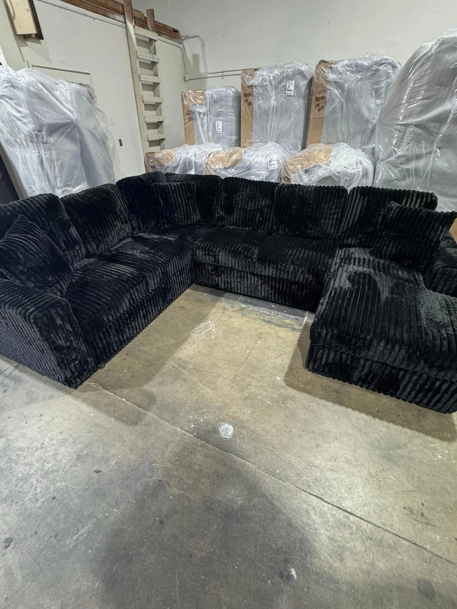 Black plush sectional staged outdoors in the sun