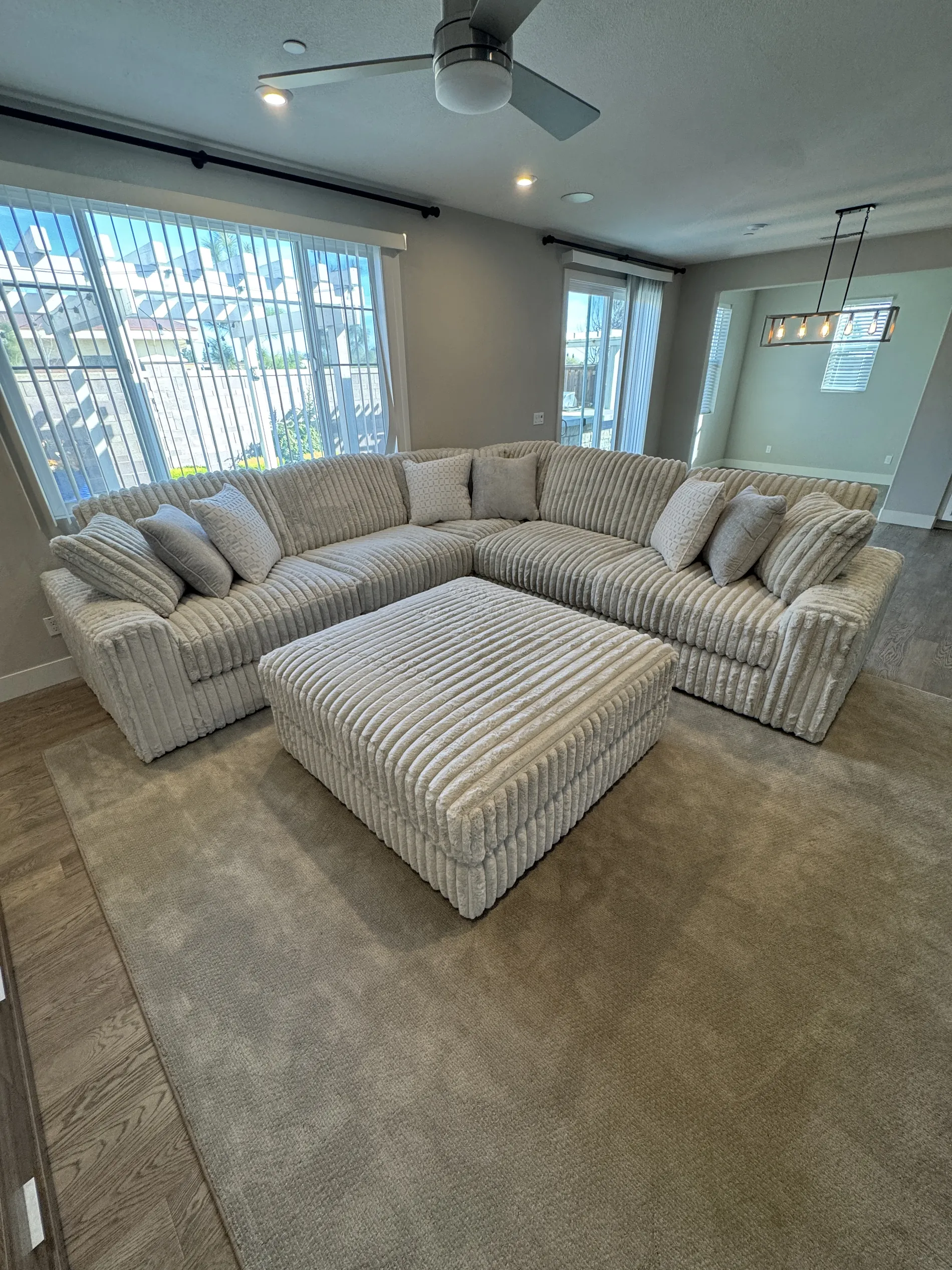 Sterling Cloud Sectional in dove grey, styled by large windows with ottoman