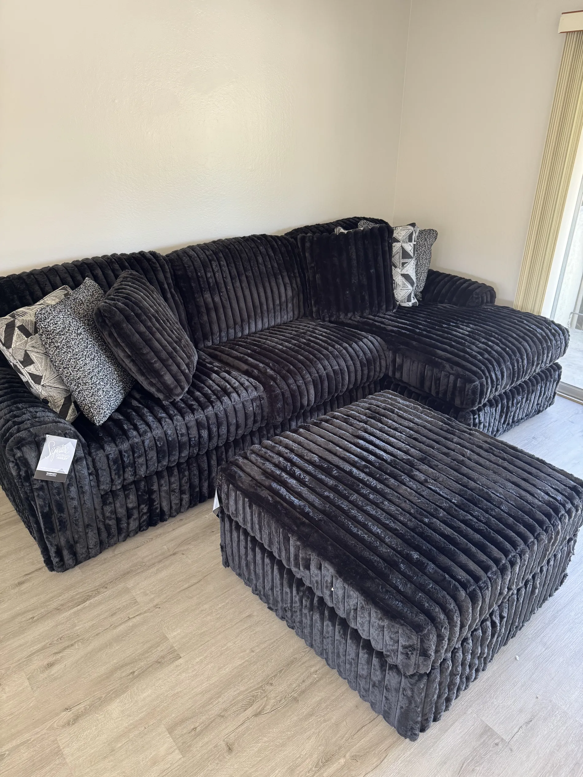 Black plush sectional with ottoman ready to enjoy