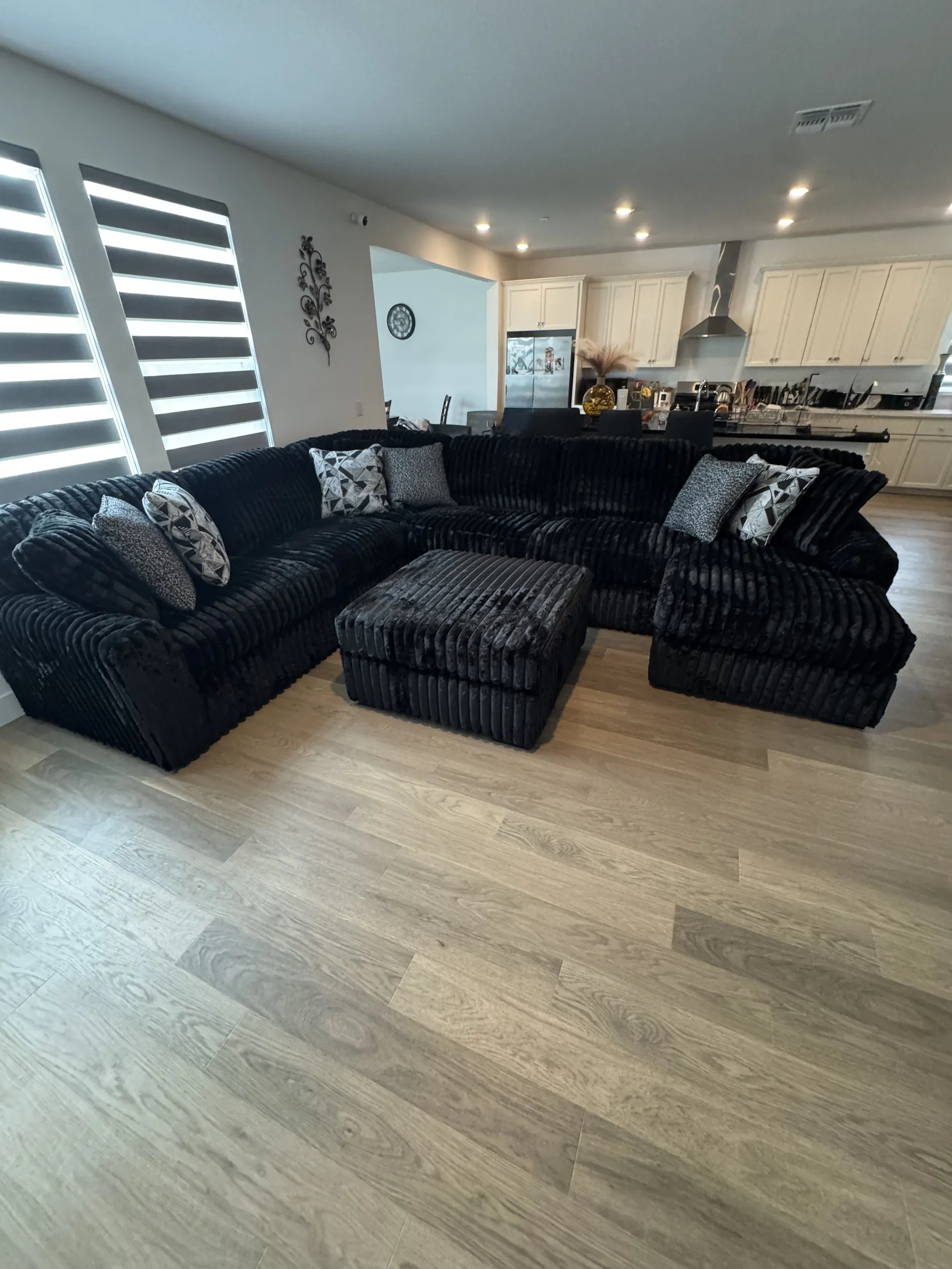 Black plush sectional in a bright modern open-plan kitchen